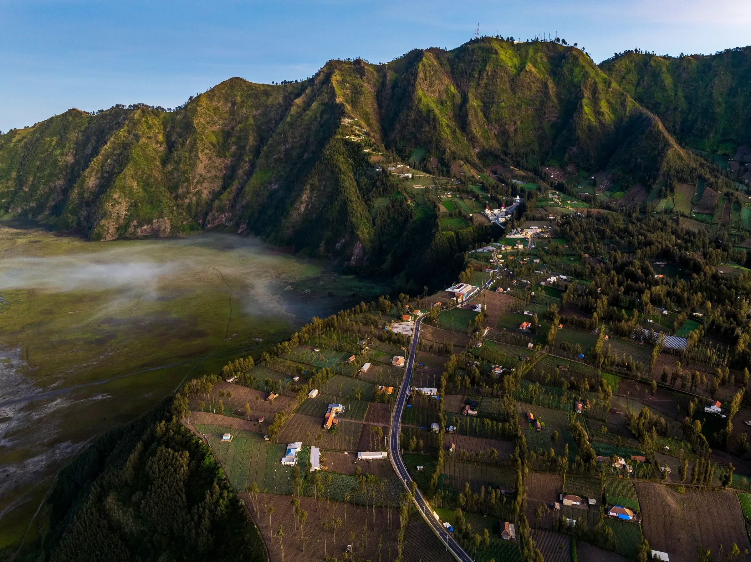 Cemoro Lawang village below the green caldera wall at Bromo, East Java