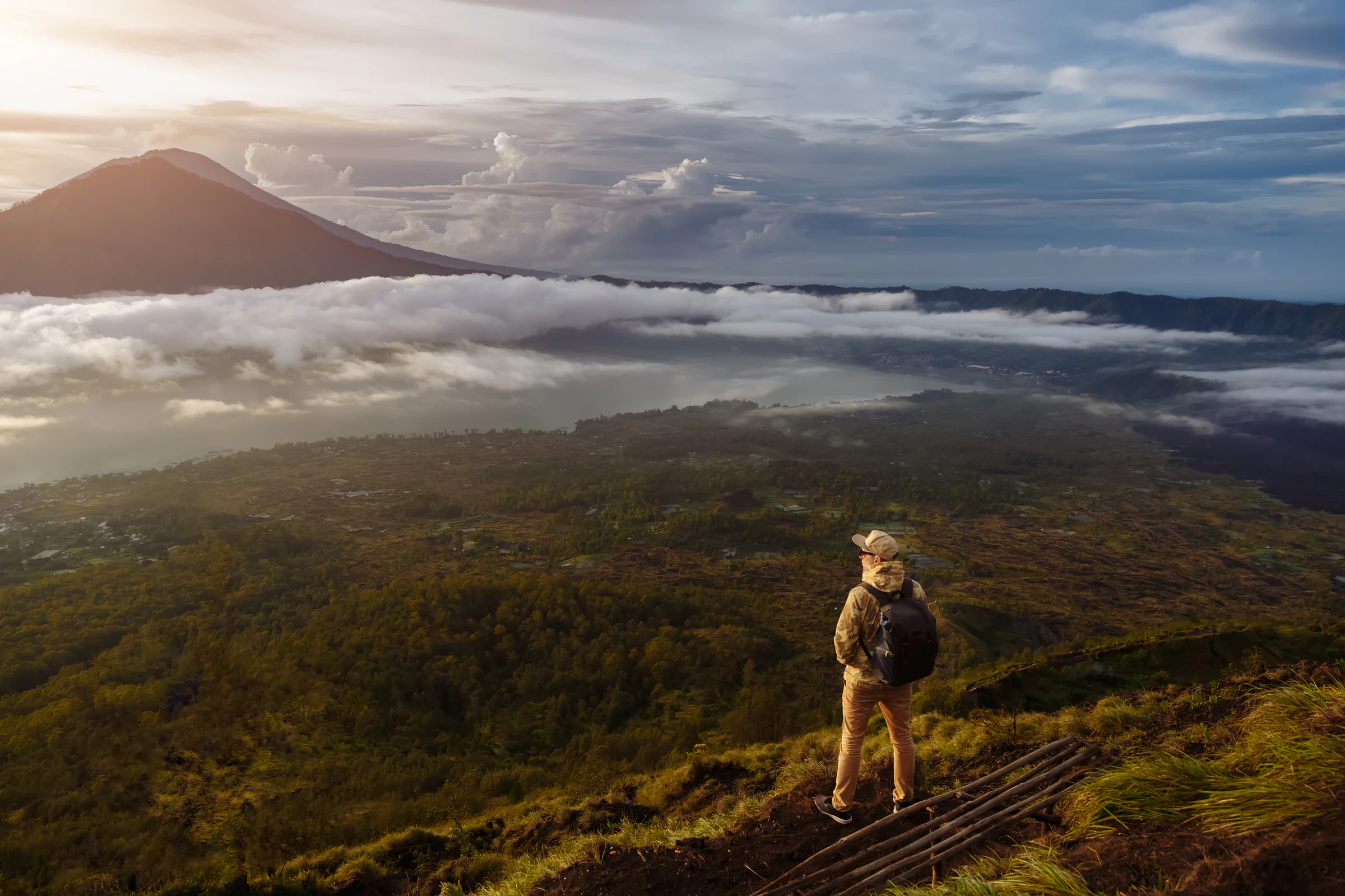 A hiker above the clouds on Mount Batur at first light