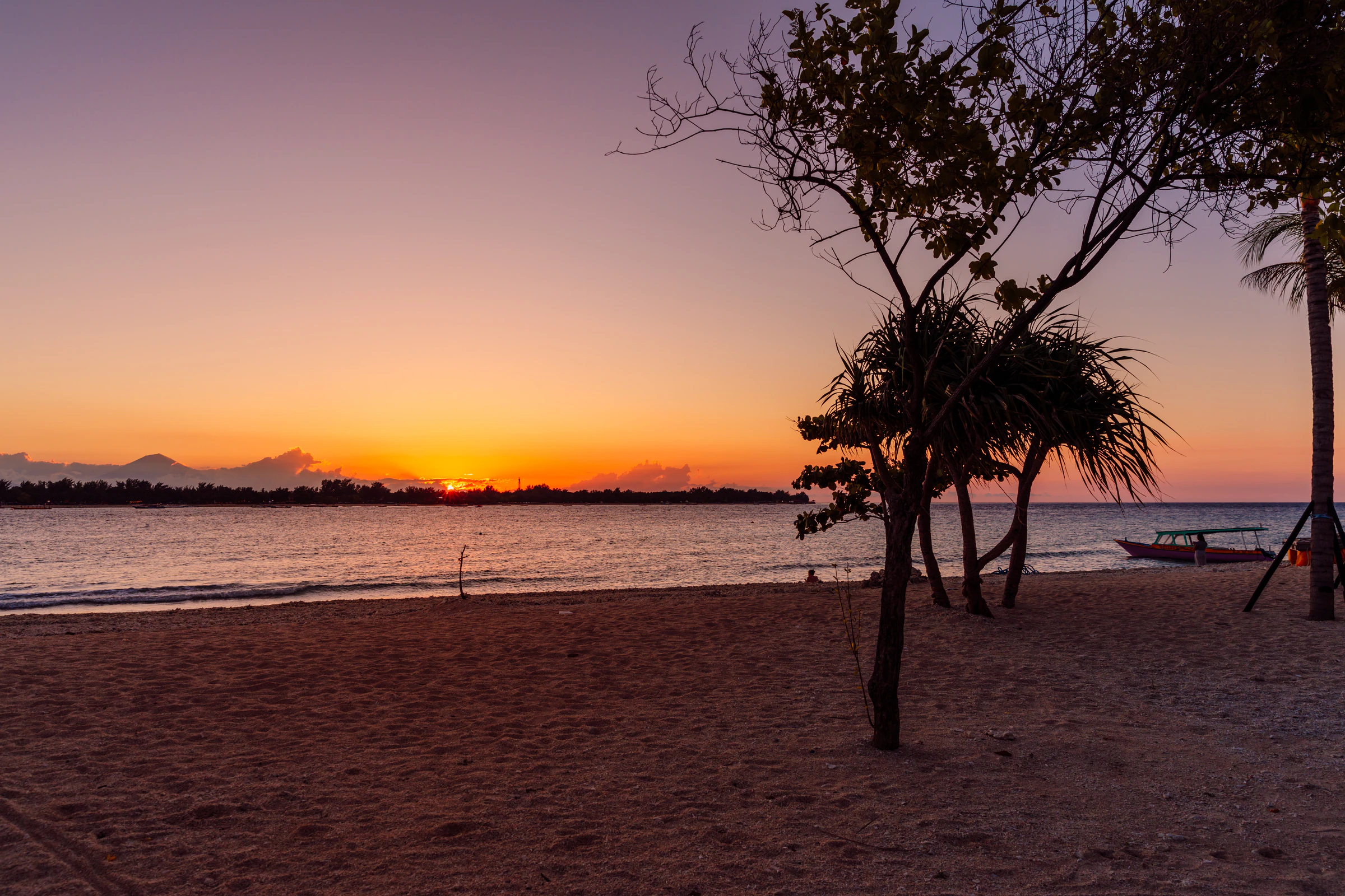 A quiet beach on Gili Trawangan at sunset, with palm trees