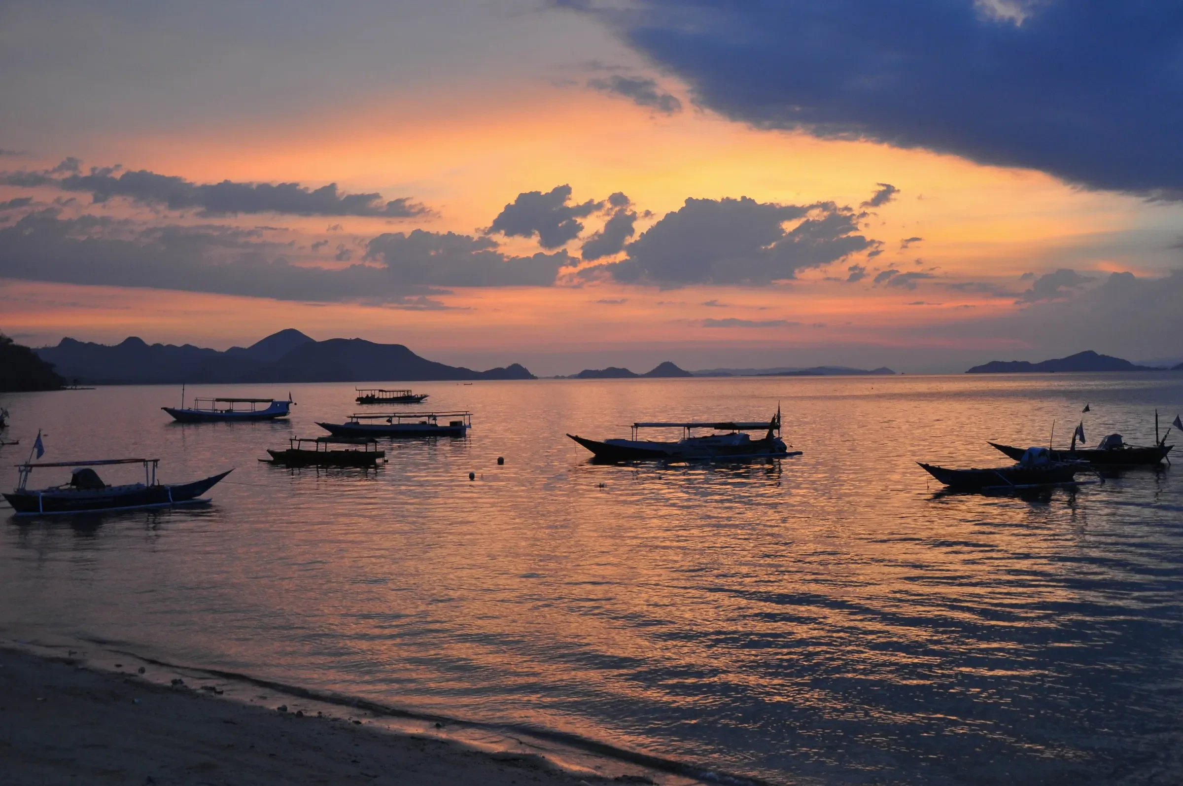 Fishing boats on calm water at sunset off Labuan Bajo