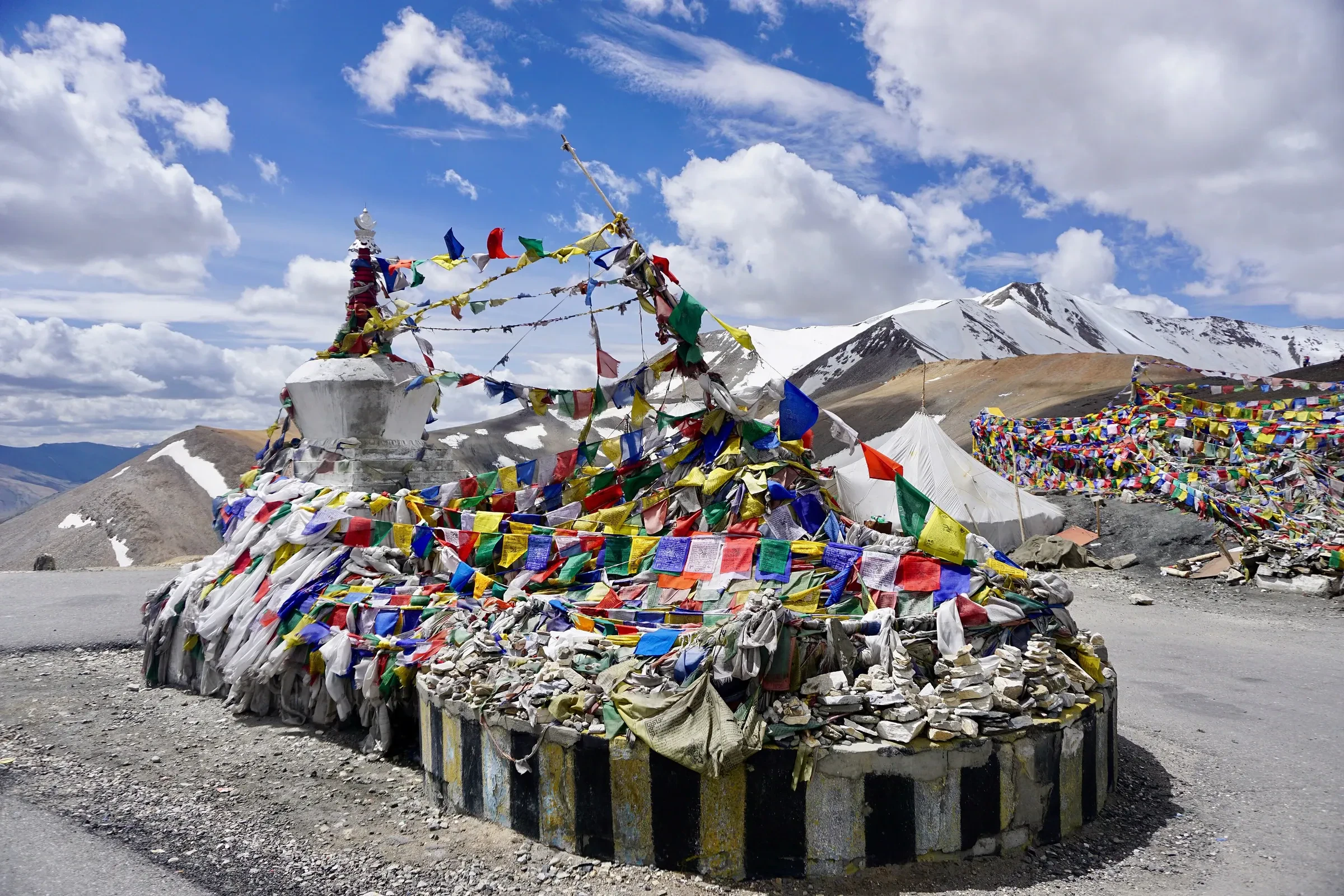 A chorten draped in prayer flags at Tanglang La pass on the Manali to Leh road