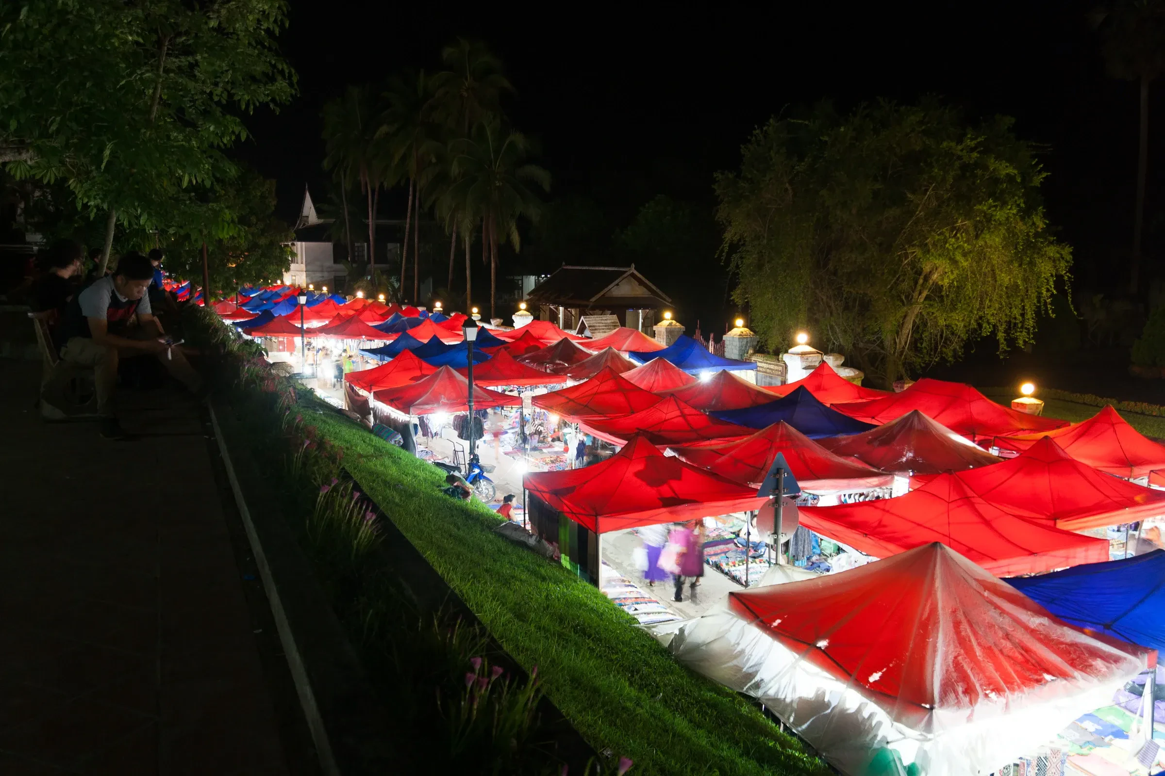 Red-roofed stalls lit up at night at the Luang Prabang night market