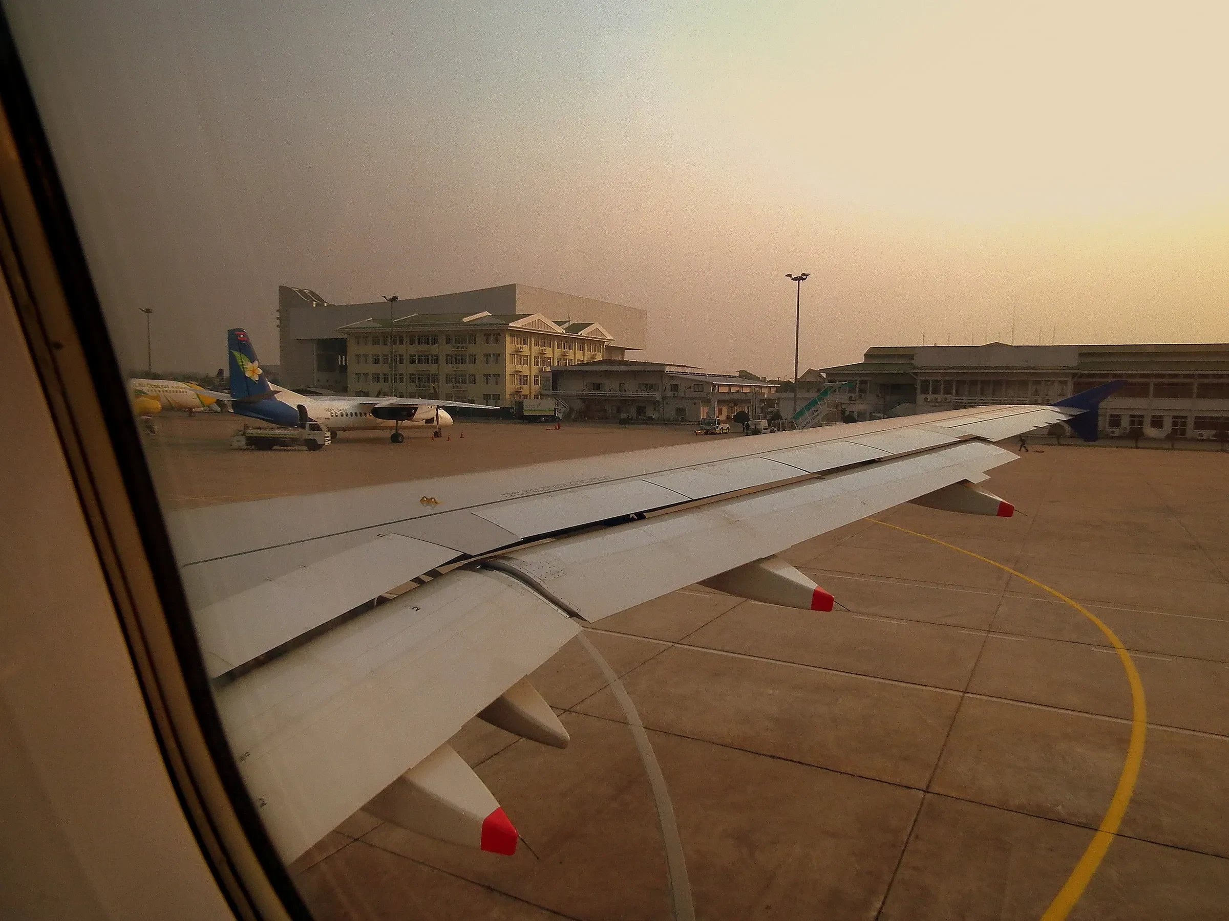 Planes and the terminal at Wattay airport in Vientiane seen from a plane window