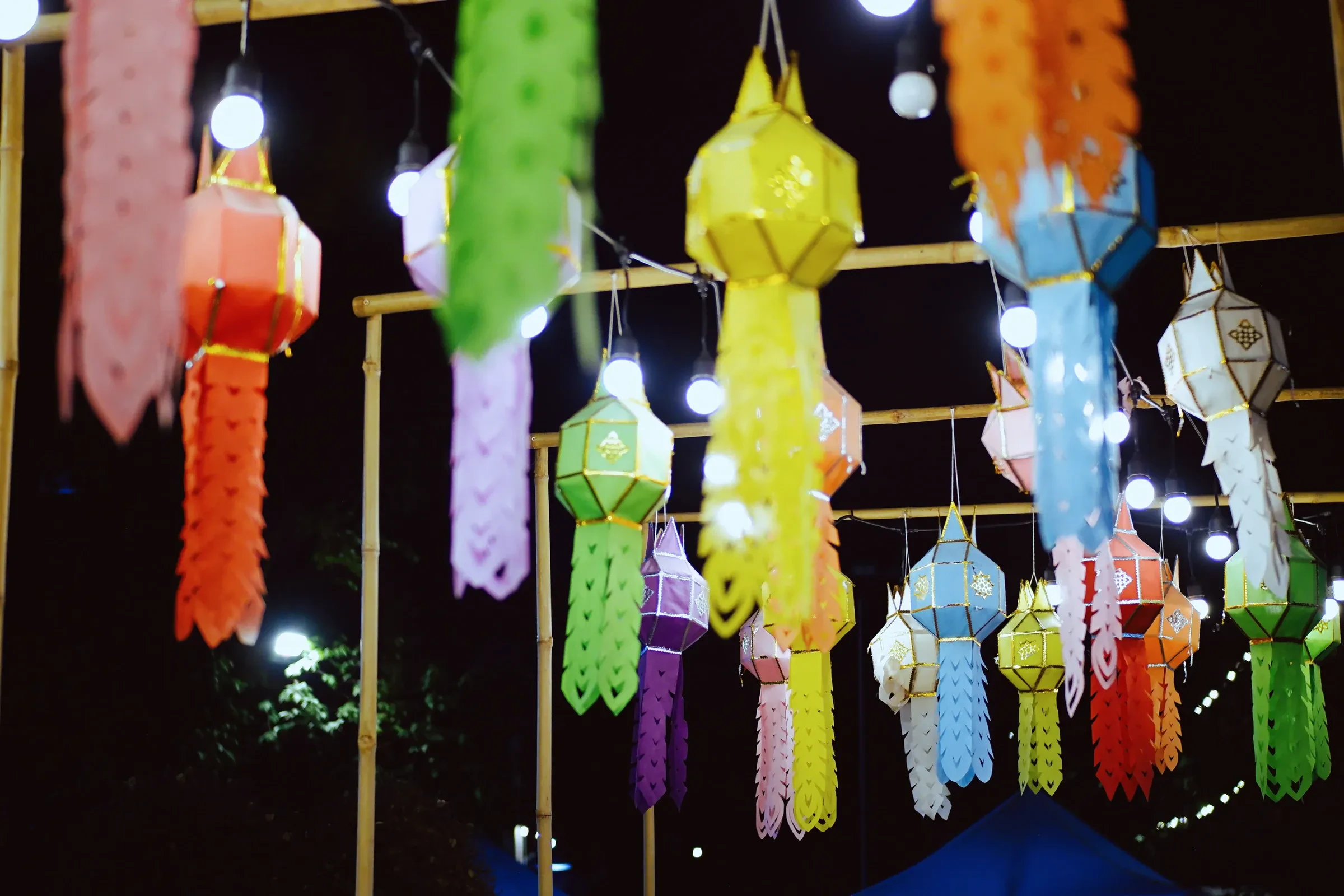 Colourful paper lanterns hanging on poles at a night festival in northern Thailand