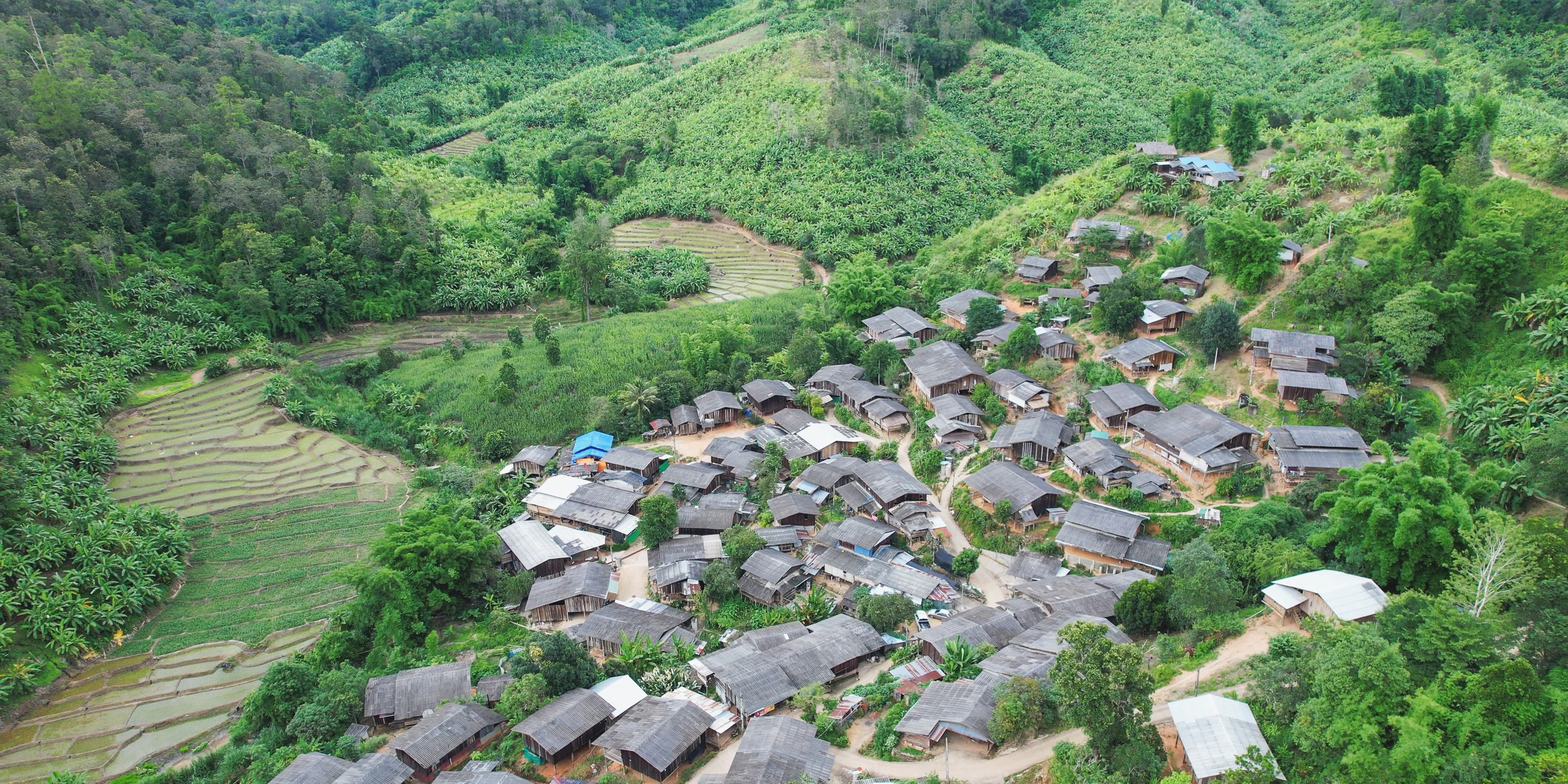 A village of grey-roofed houses among green terraced hills in northern Vietnam