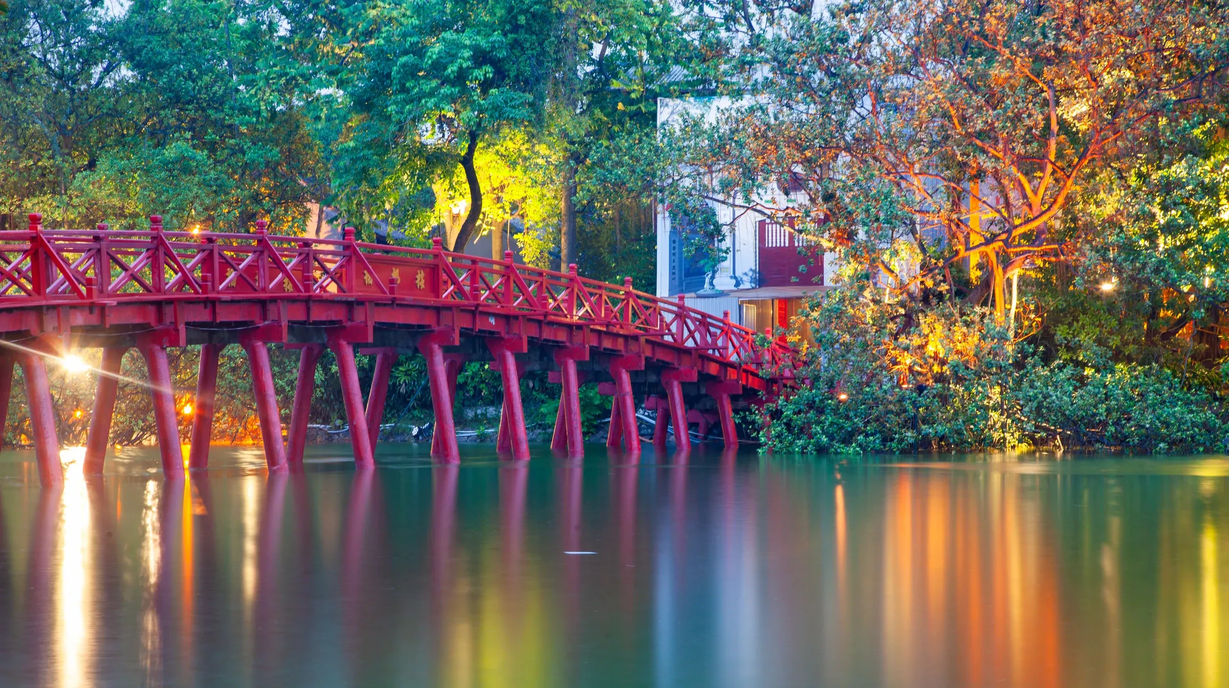 The red Huc Bridge lit up on Hoan Kiem Lake in Hanoi