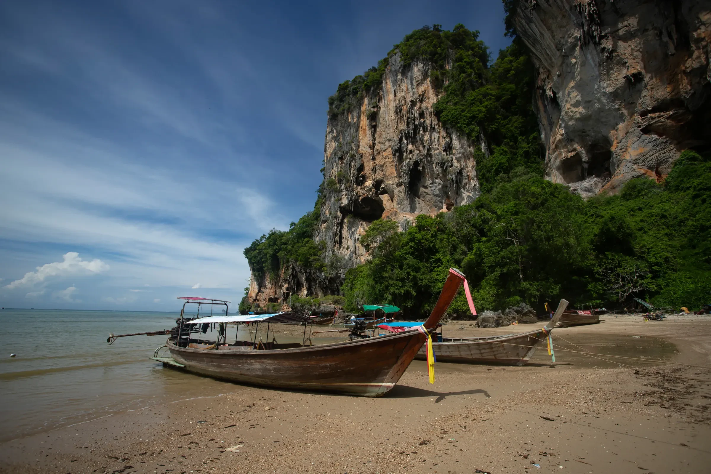Longtail boats on Tonsai beach beneath a limestone cliff
