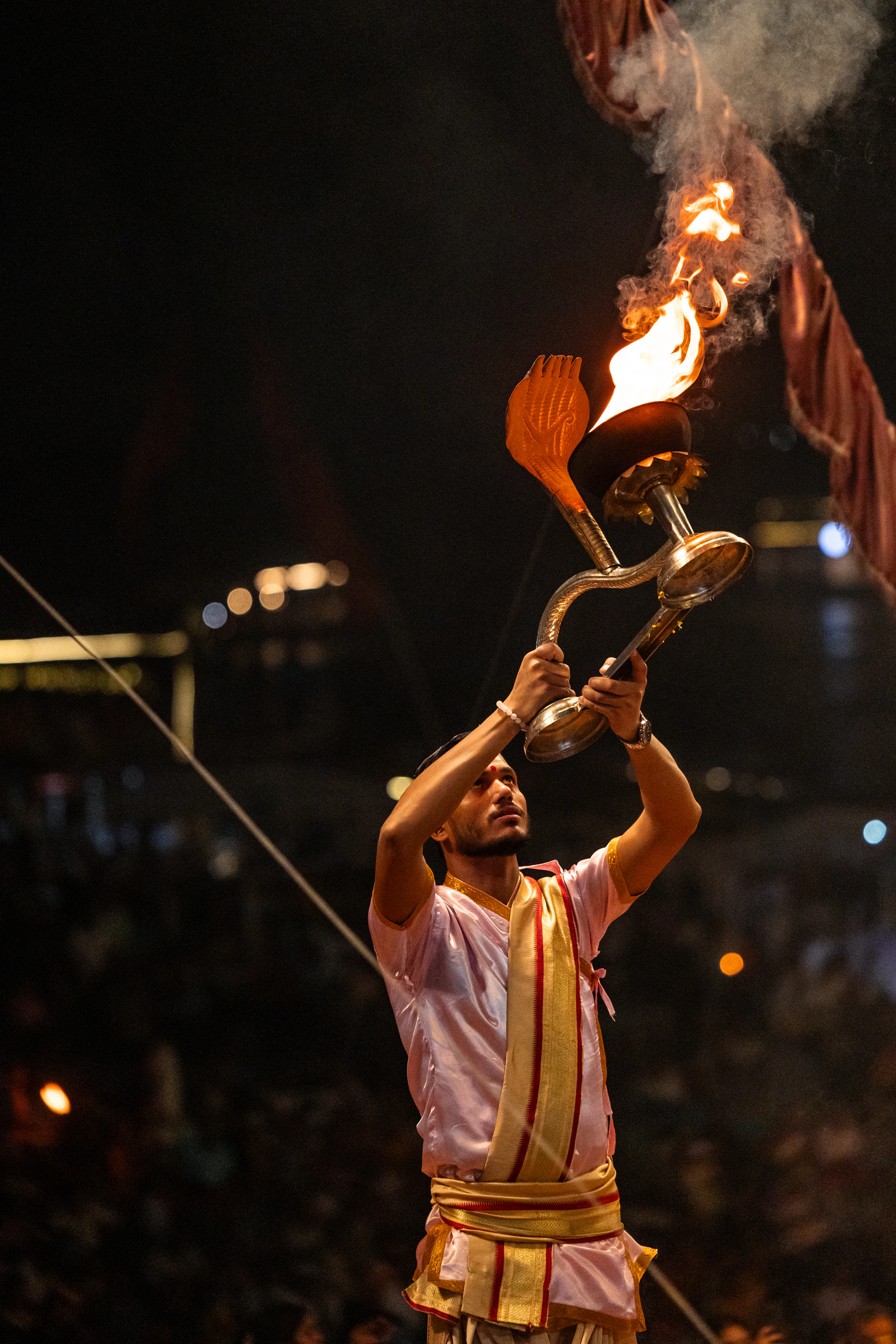A priest raising a fire lamp during the evening Ganga aarti in Varanasi
