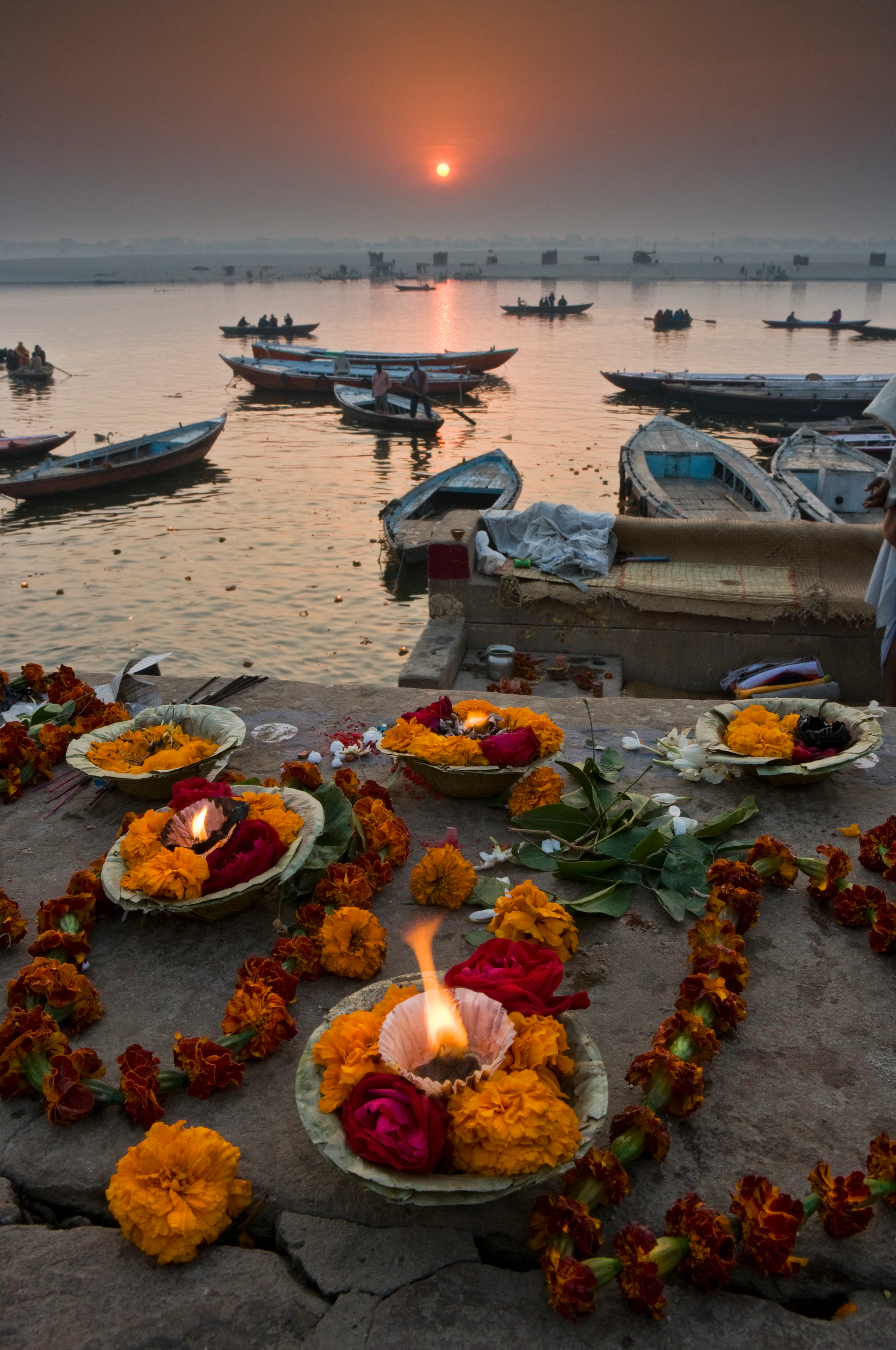 Boats and marigold offerings on the Varanasi ghats at sunrise