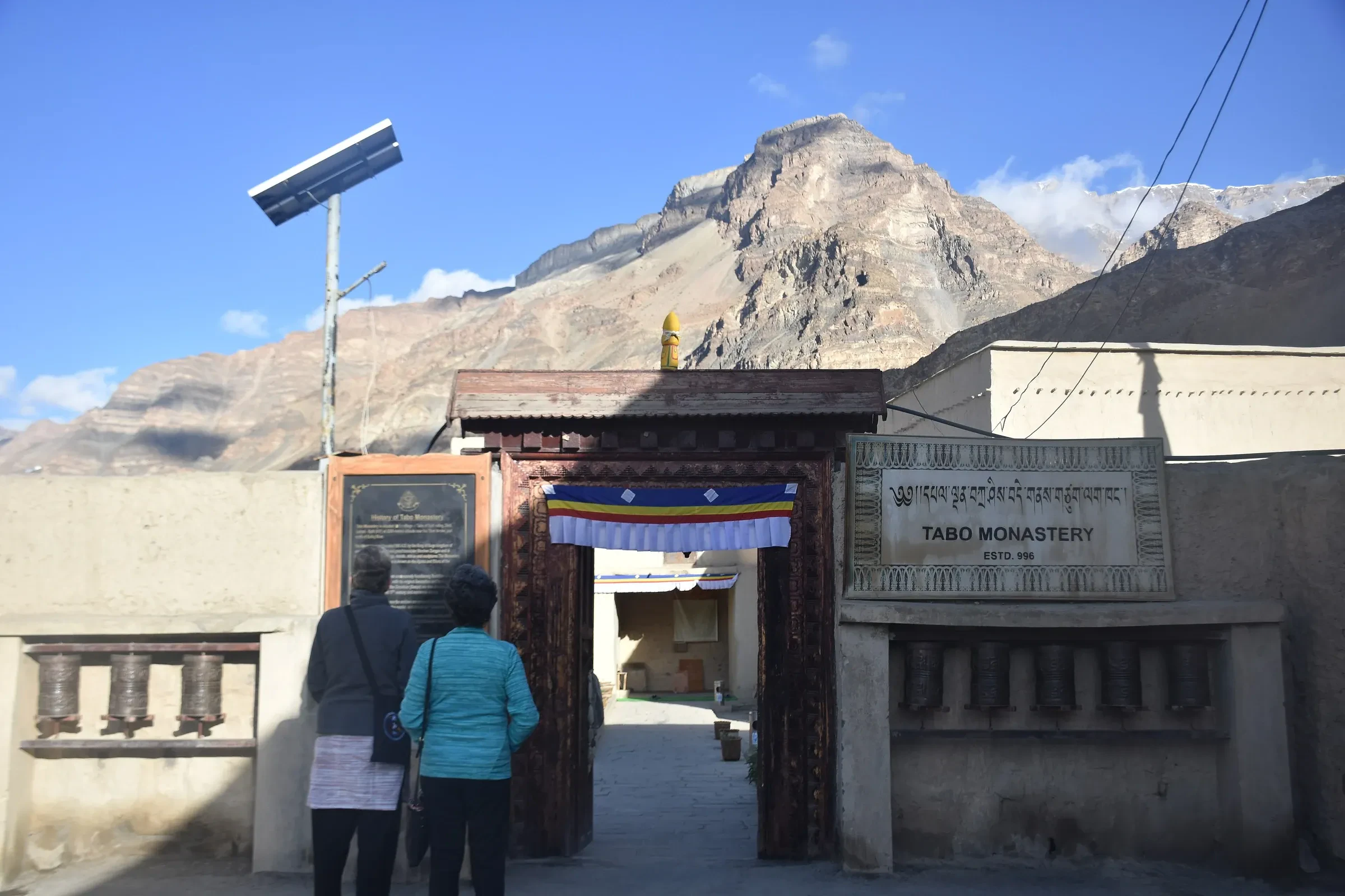The entrance gate of Tabo Monastery with prayer wheels along the wall