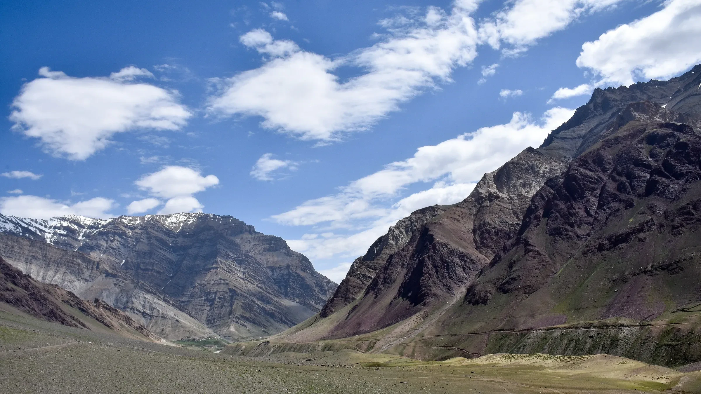 The wide Pin Valley with snow-dusted mountains above a green valley floor