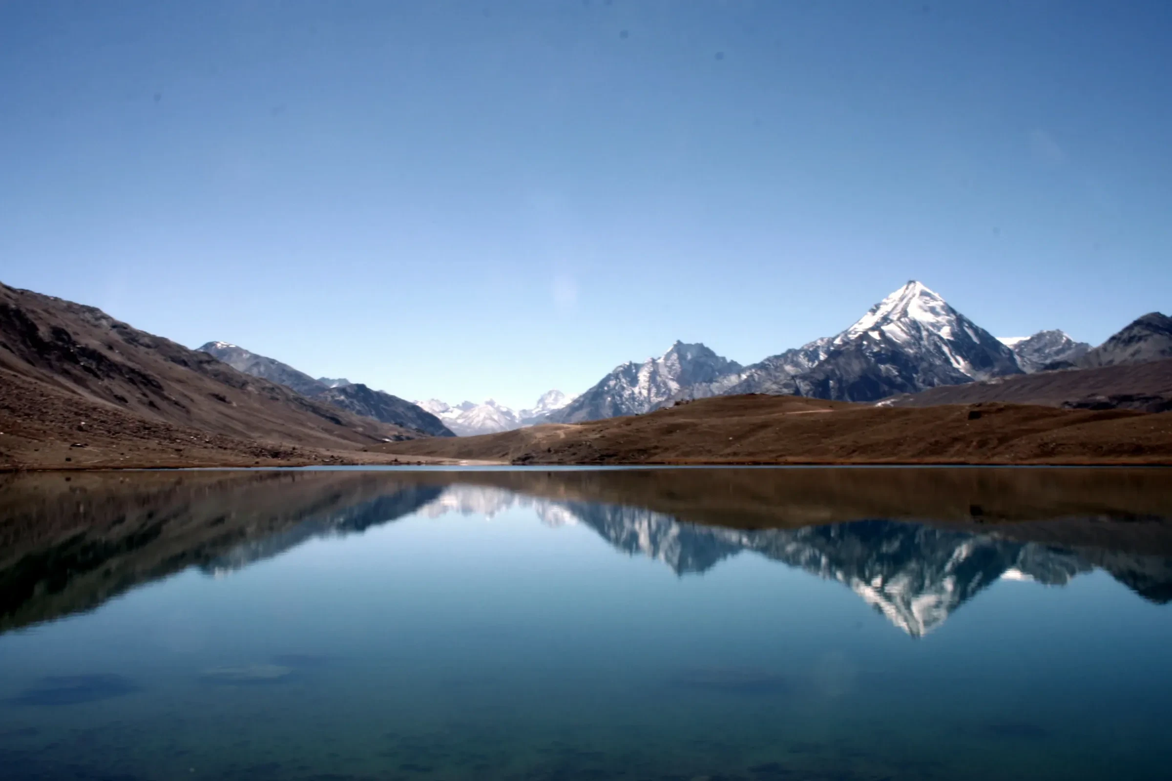 Snowy peaks reflected in the still water of Chandratal lake