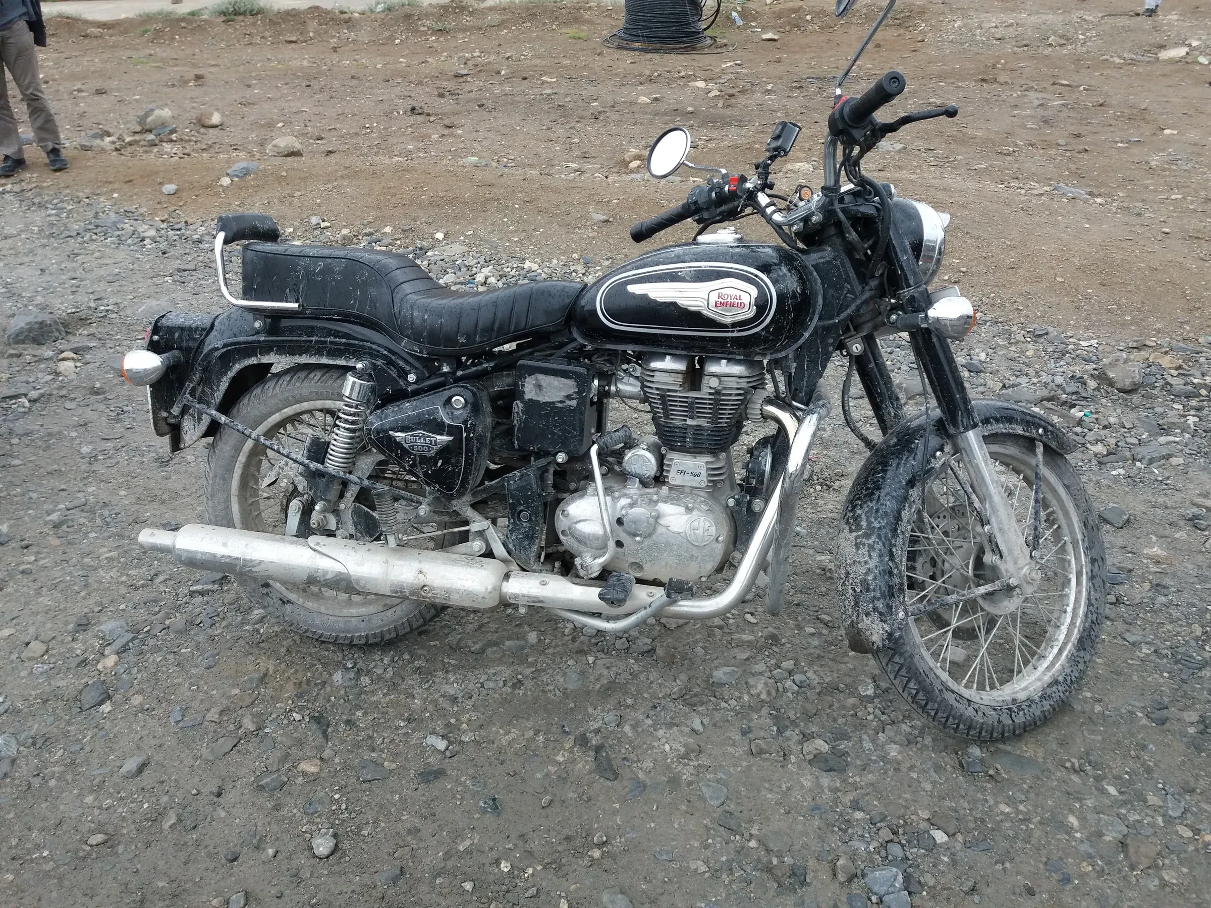 A motorcycle parked on a gravel roadside on the Leh-Manali highway