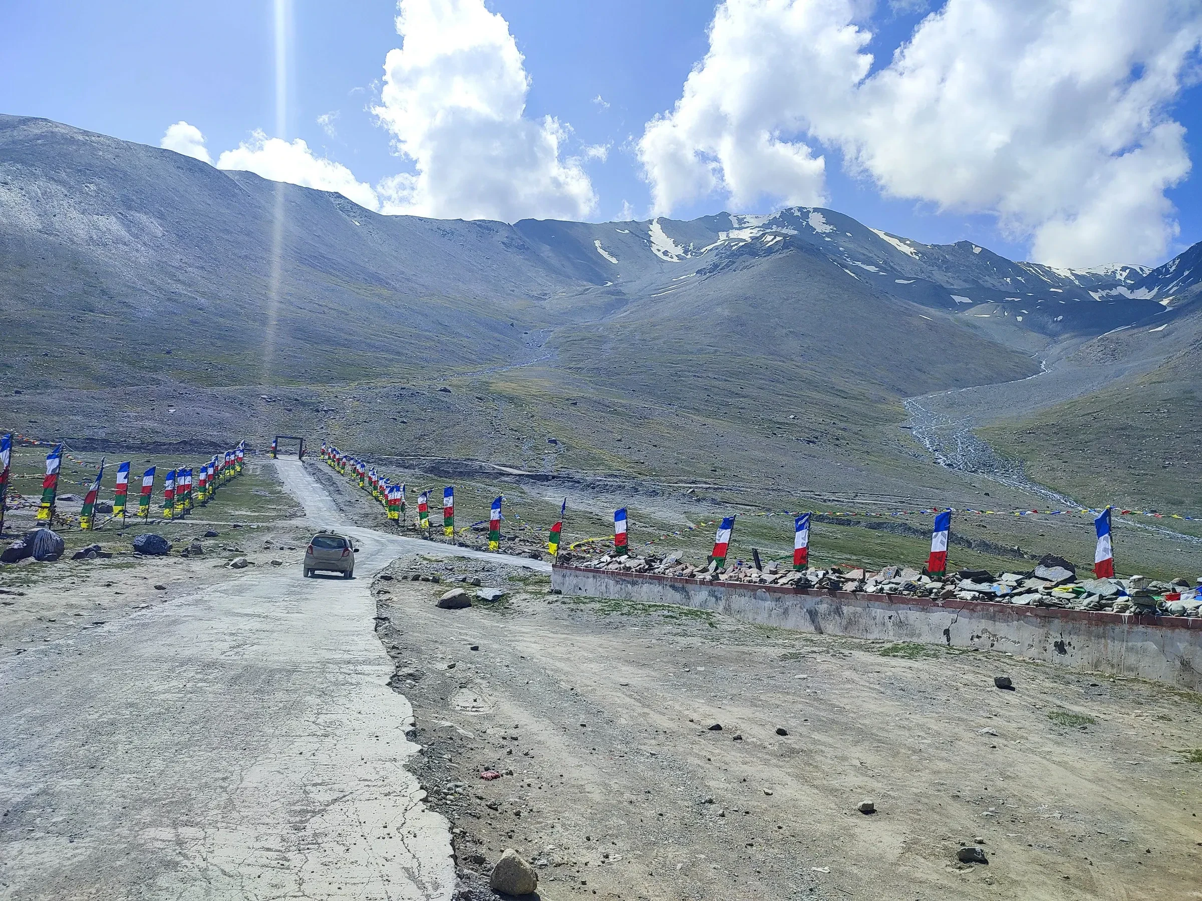 The road over Kunzum La with lines of prayer flags along the pass top