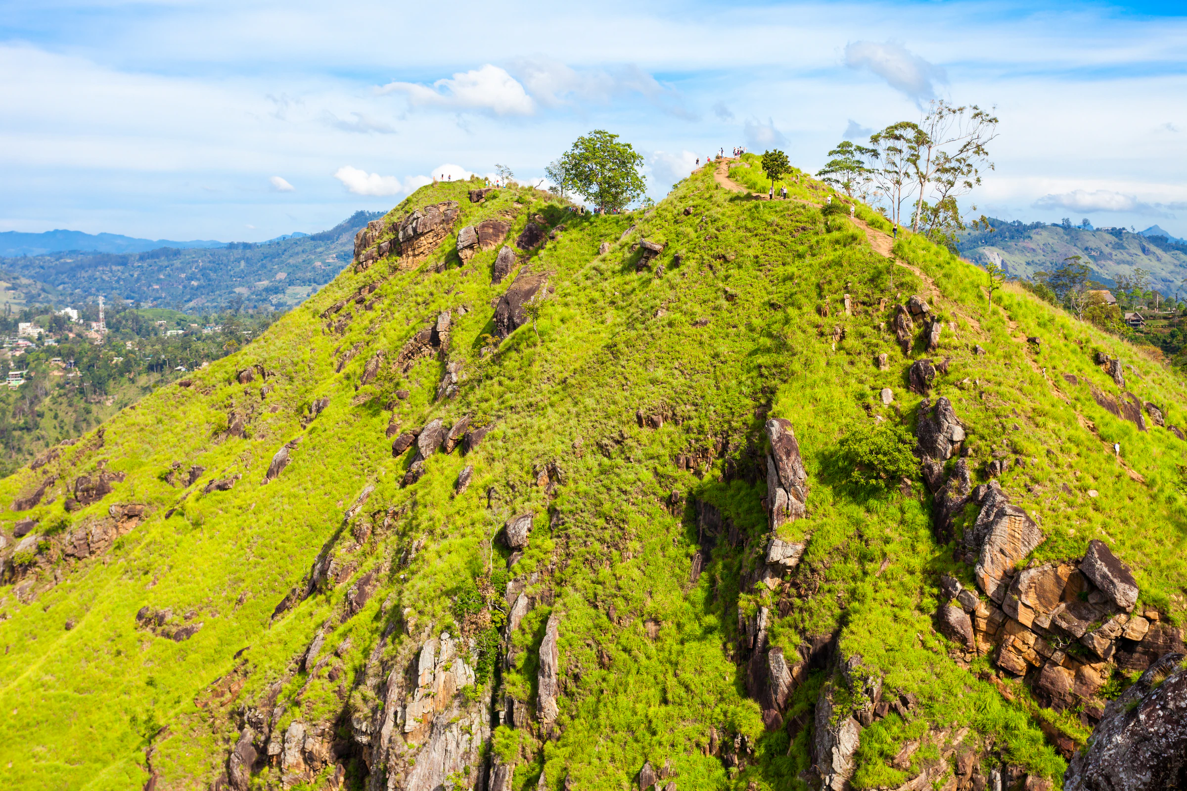 A steep green peak with rocky outcrops above Ella