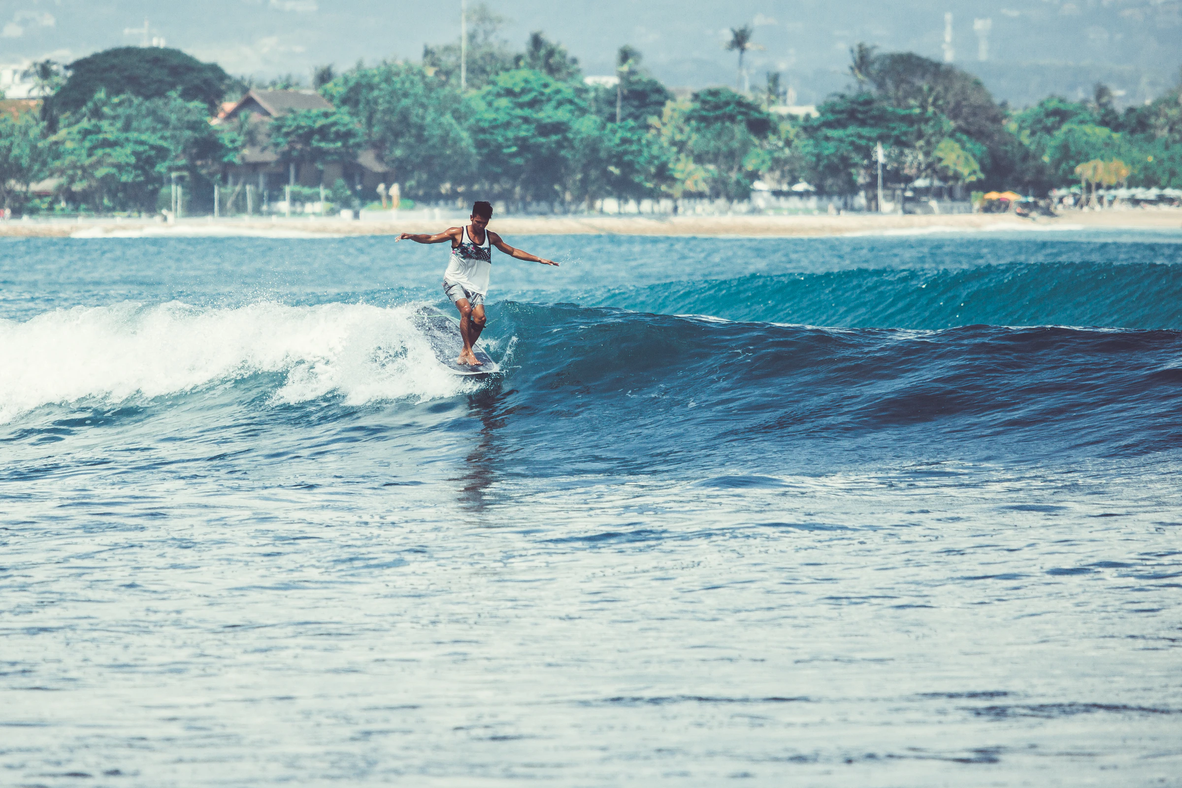 A surfer riding a clean wave toward the shore