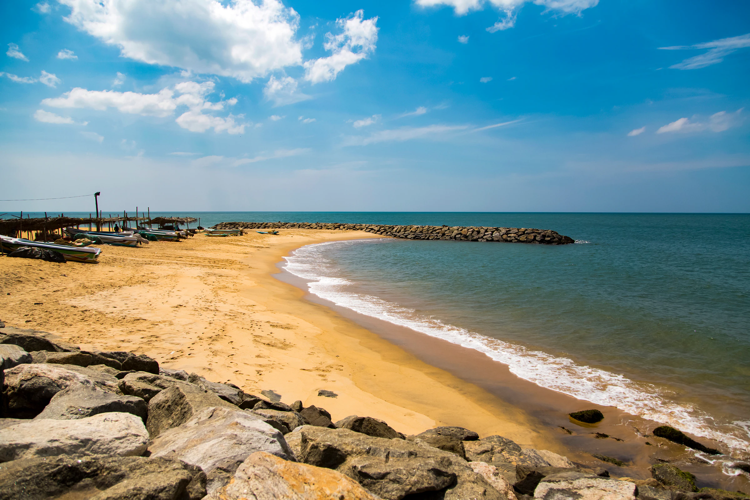 A sandy beach with rocks and a breakwater at Negombo