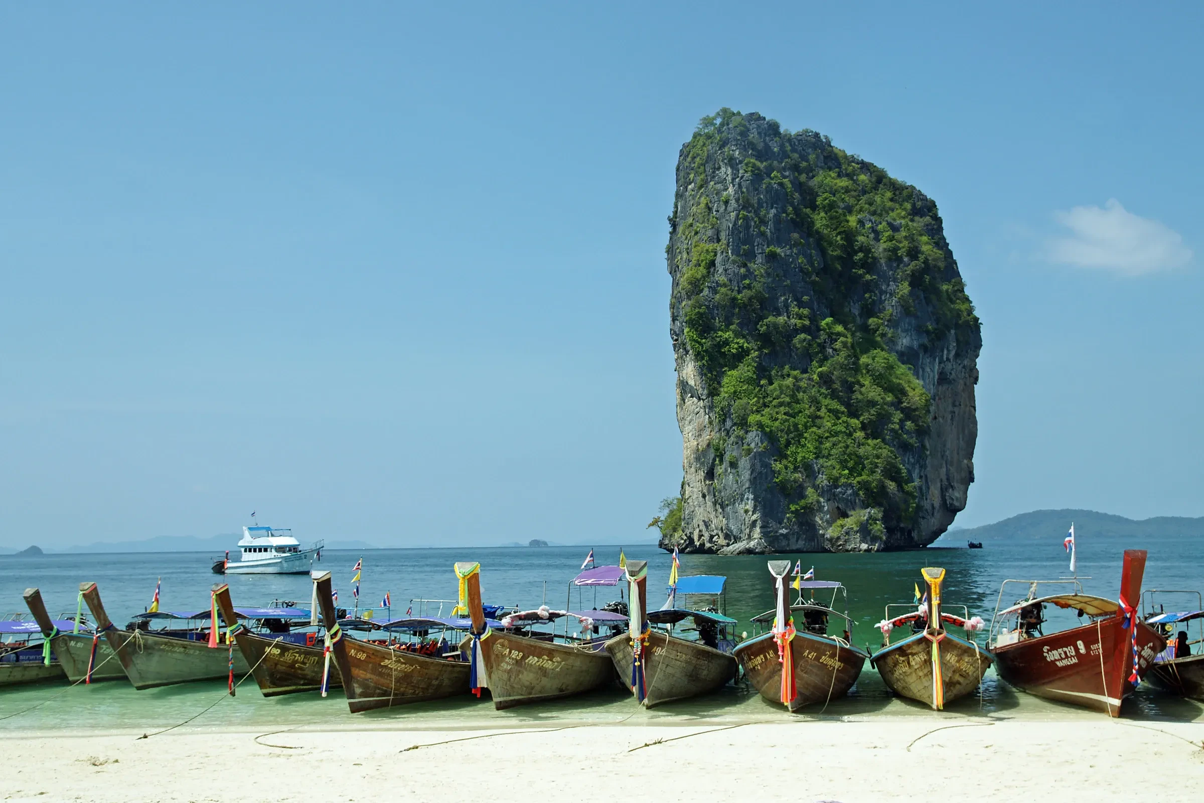 Longtail boats lined up on the beach of Poda Island in Krabi