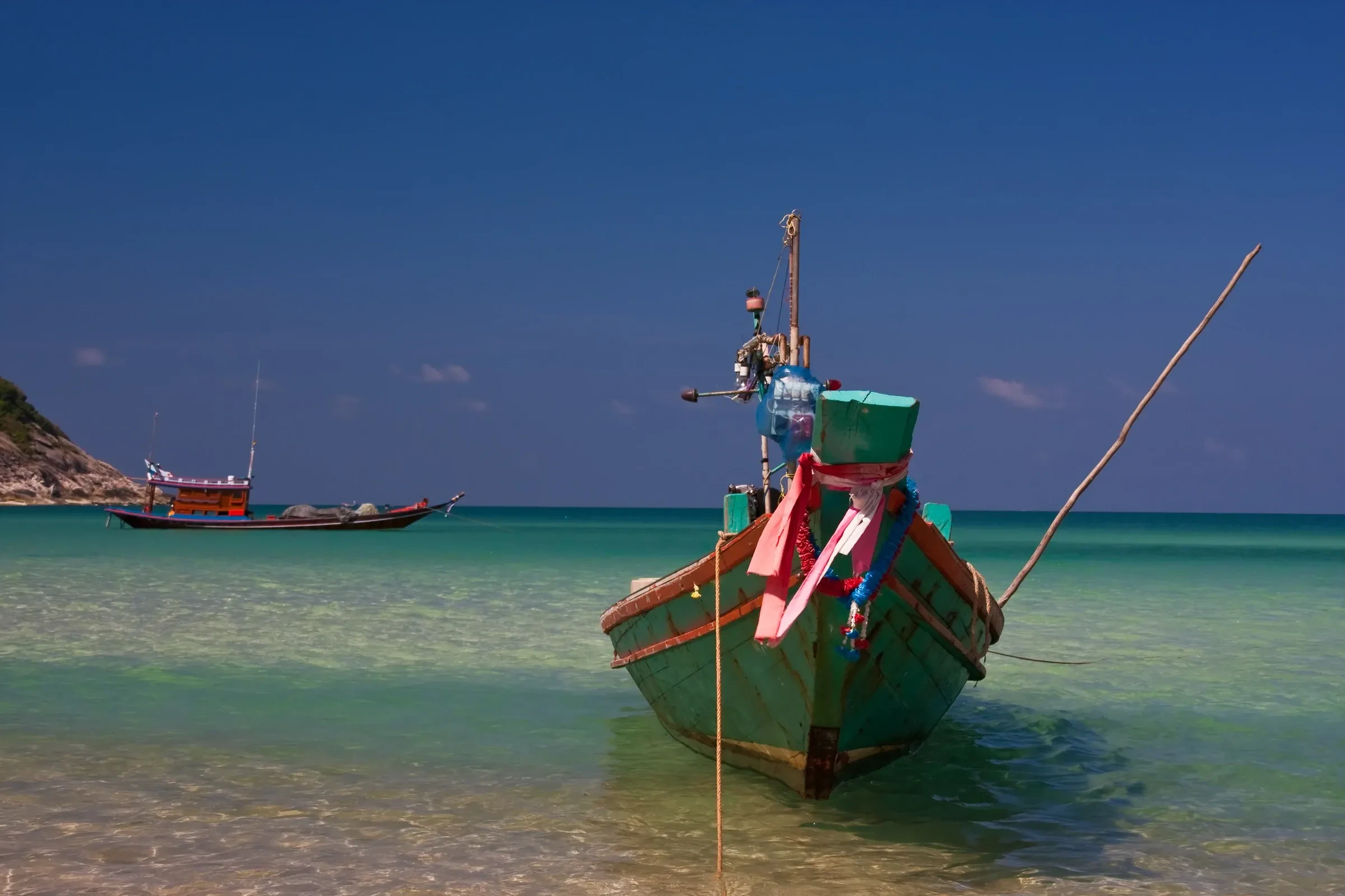 A longtail boat in clear water at Bottle Beach, Koh Phangan