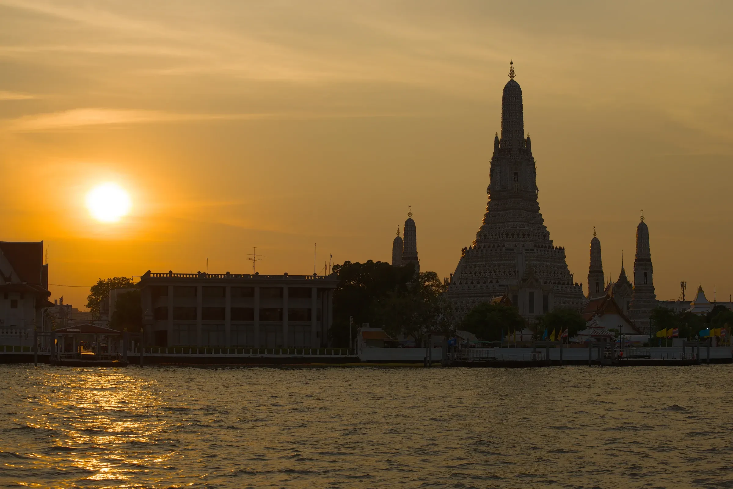 Wat Arun's tall prang against a Bangkok sunset on the Chao Phraya River