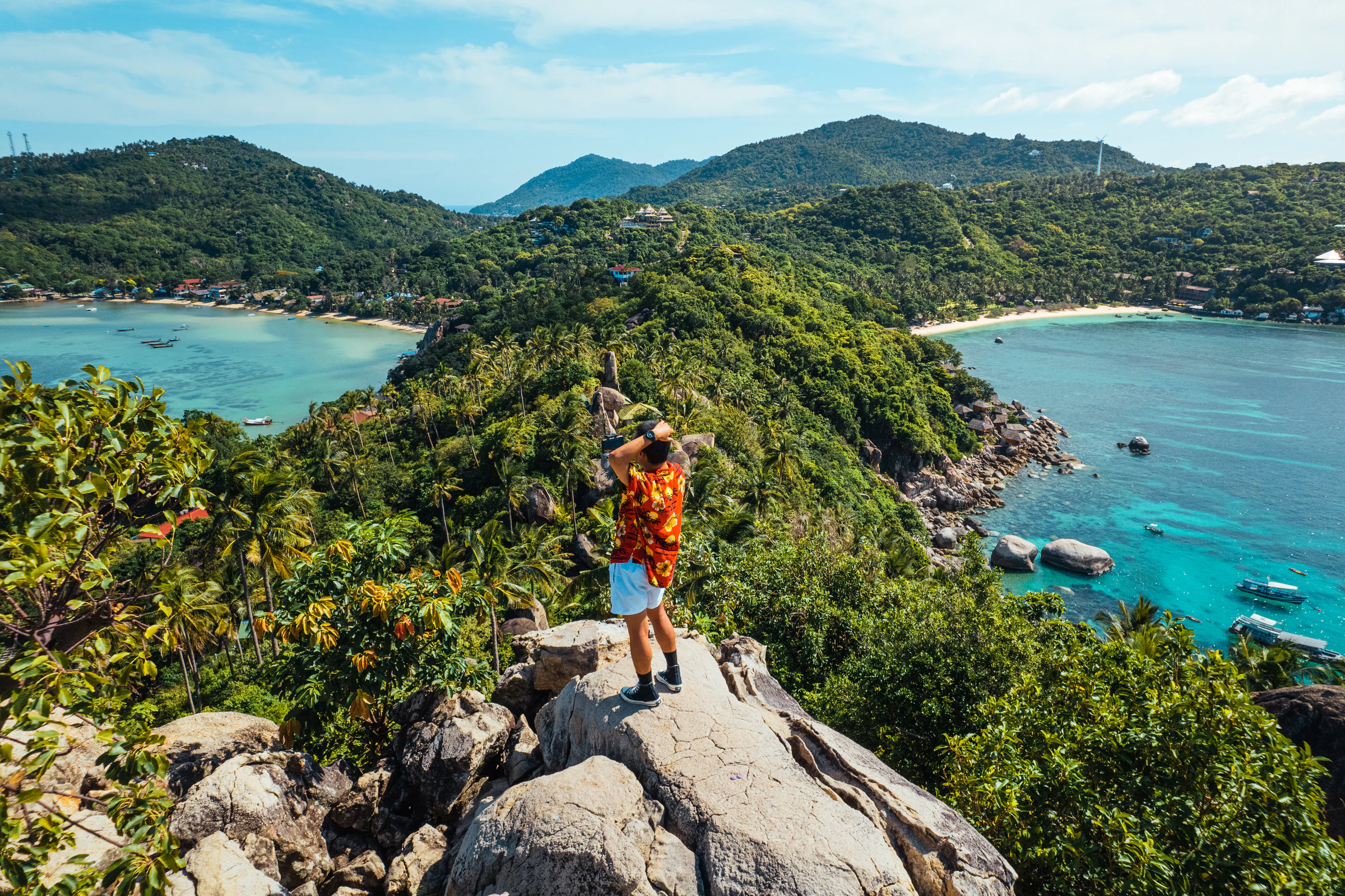 A hiker at a Koh Tao viewpoint looking over two bays