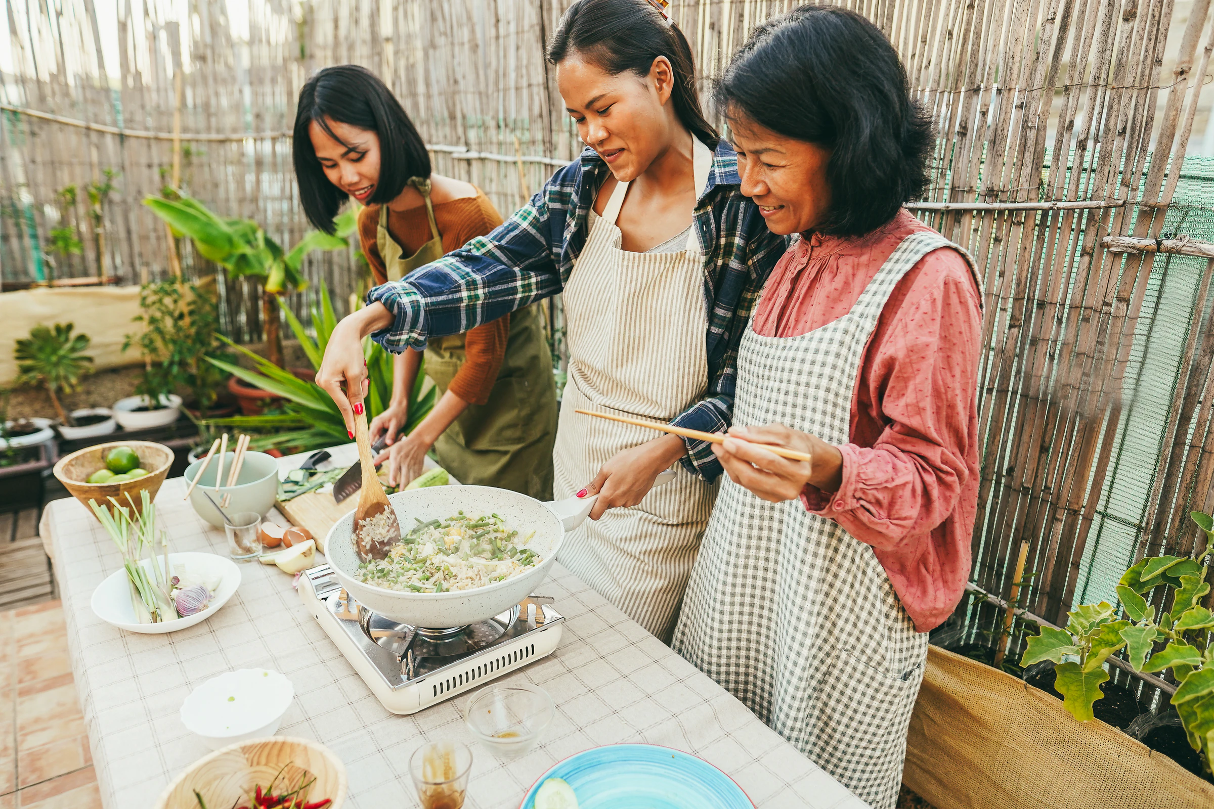 Cooking over a wok outdoors with fresh herbs and vegetables