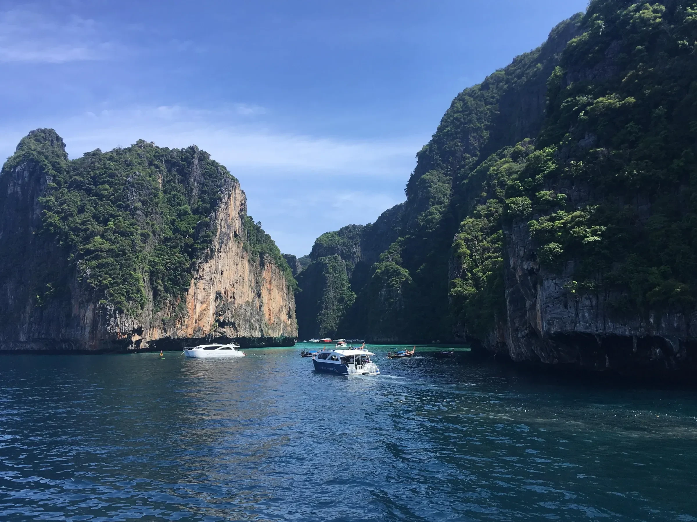 Boats in Pileh Lagoon, ringed by limestone cliffs on Koh Phi Phi Leh