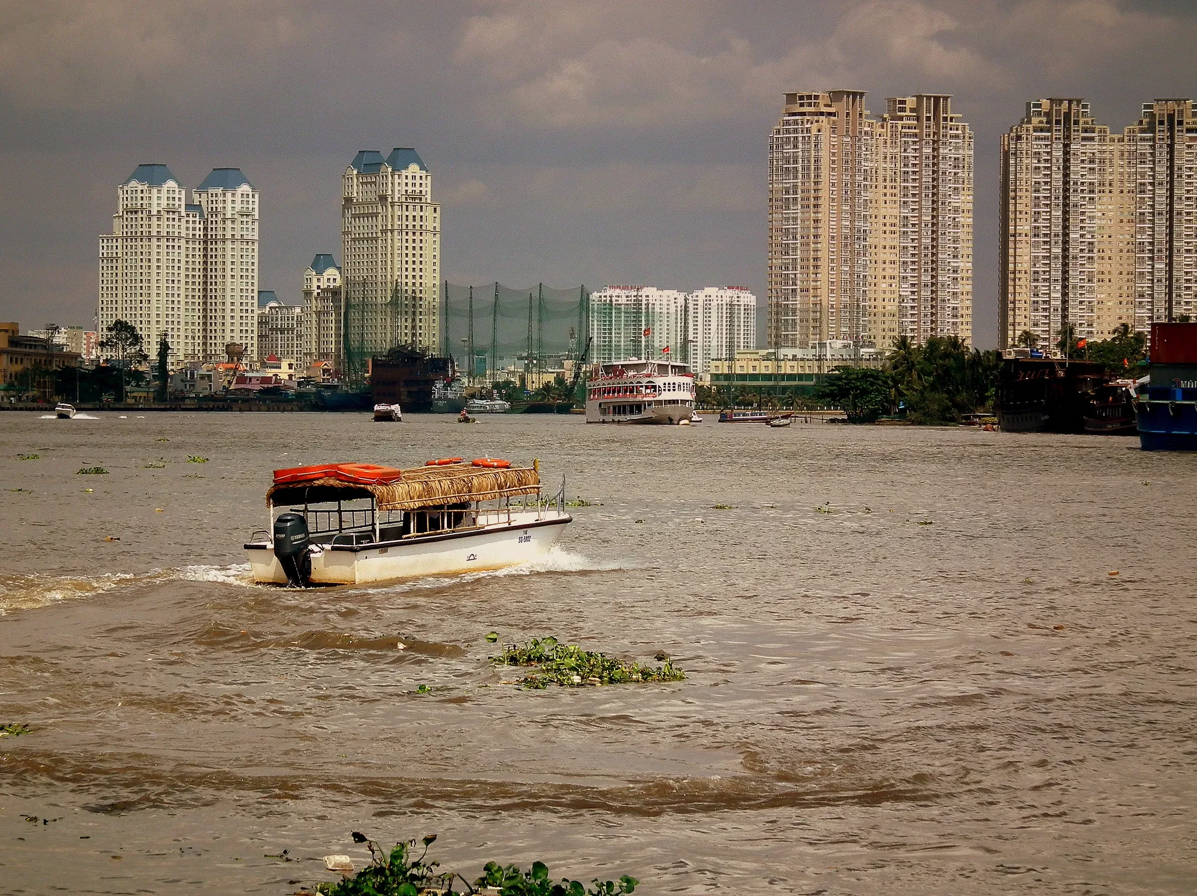 A boat on the Saigon River with high-rise towers behind