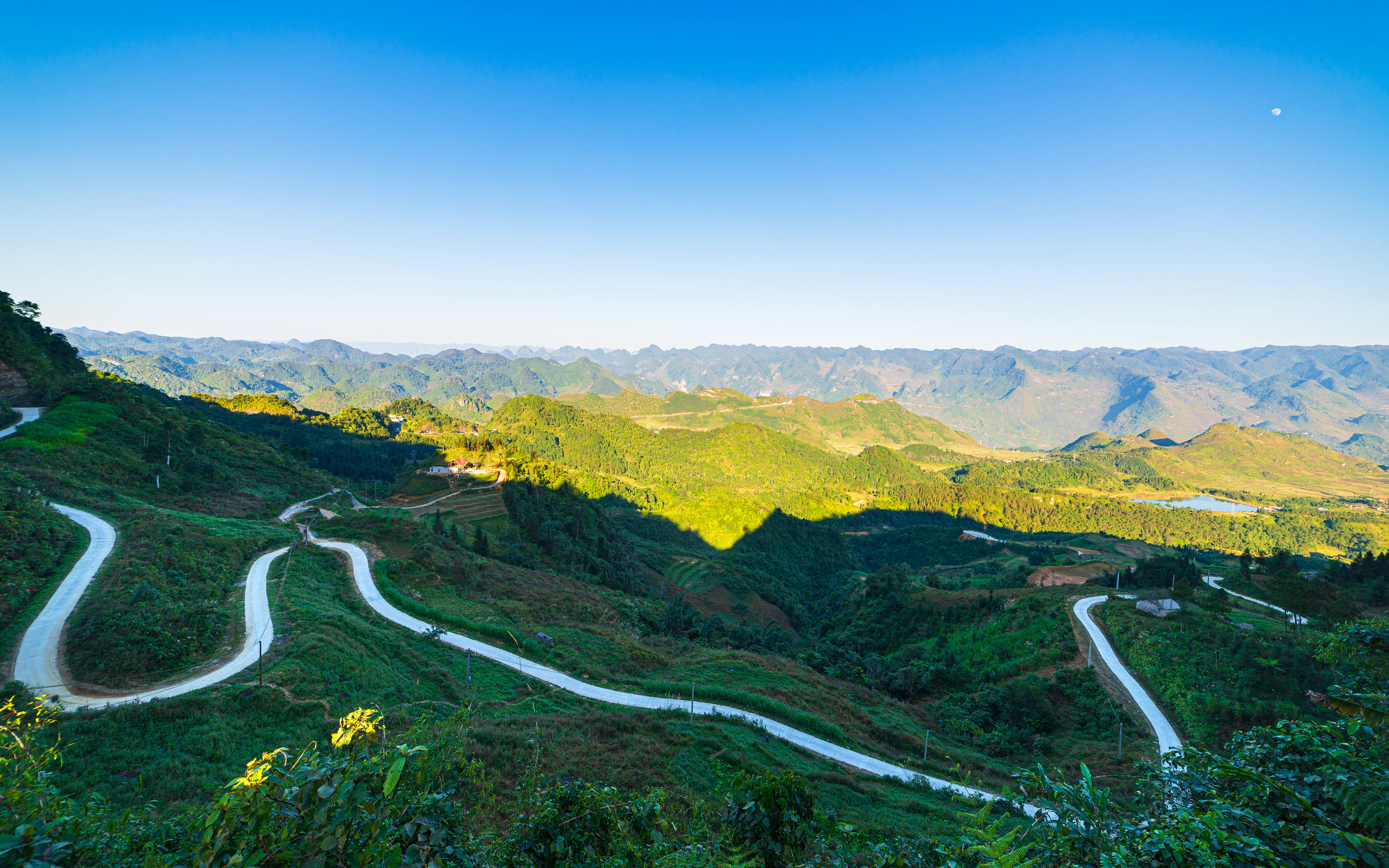 A switchback road climbing between mountains in Ha Giang