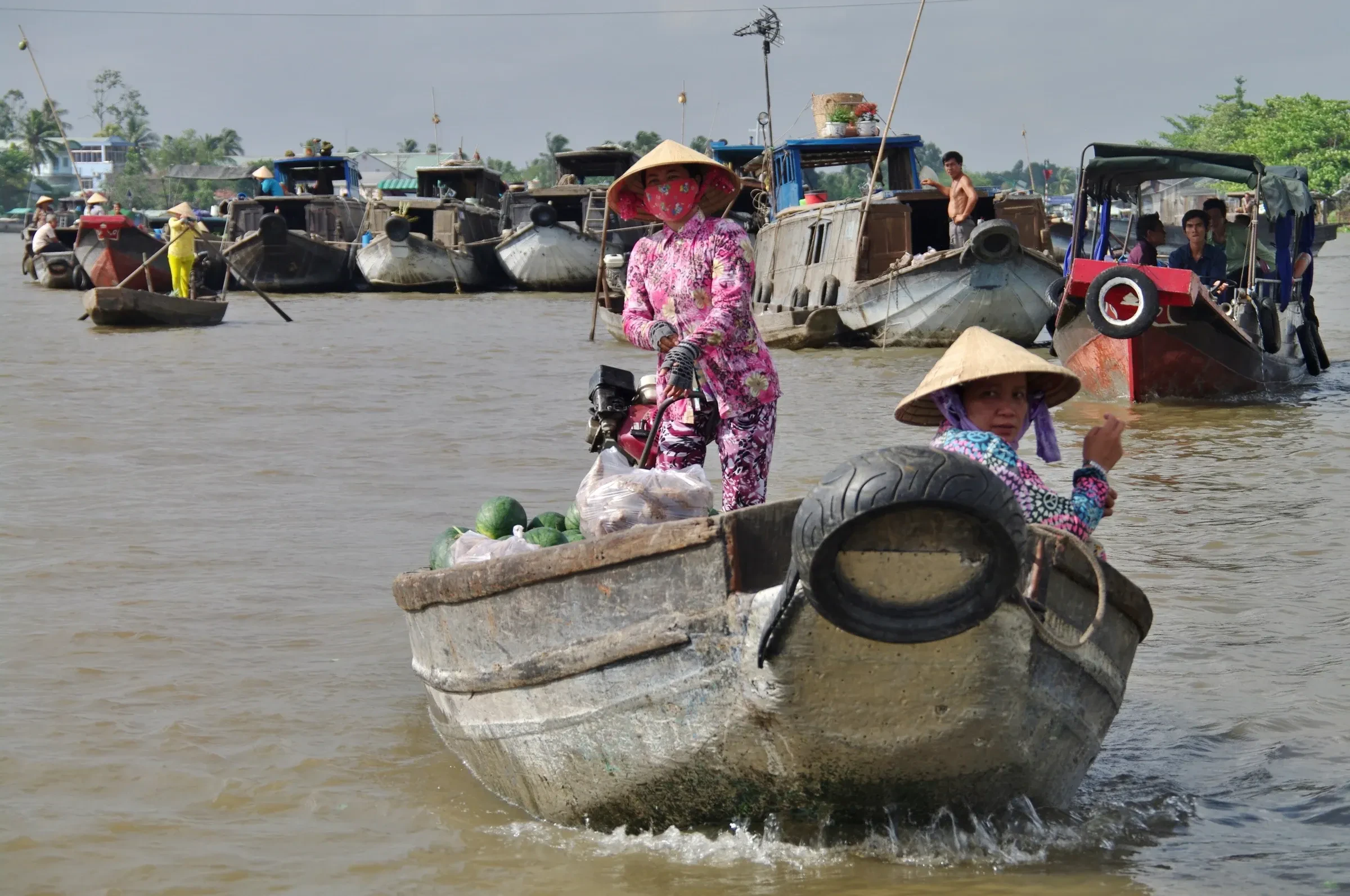 Traders in conical hats on their boats at the Cai Rang floating market