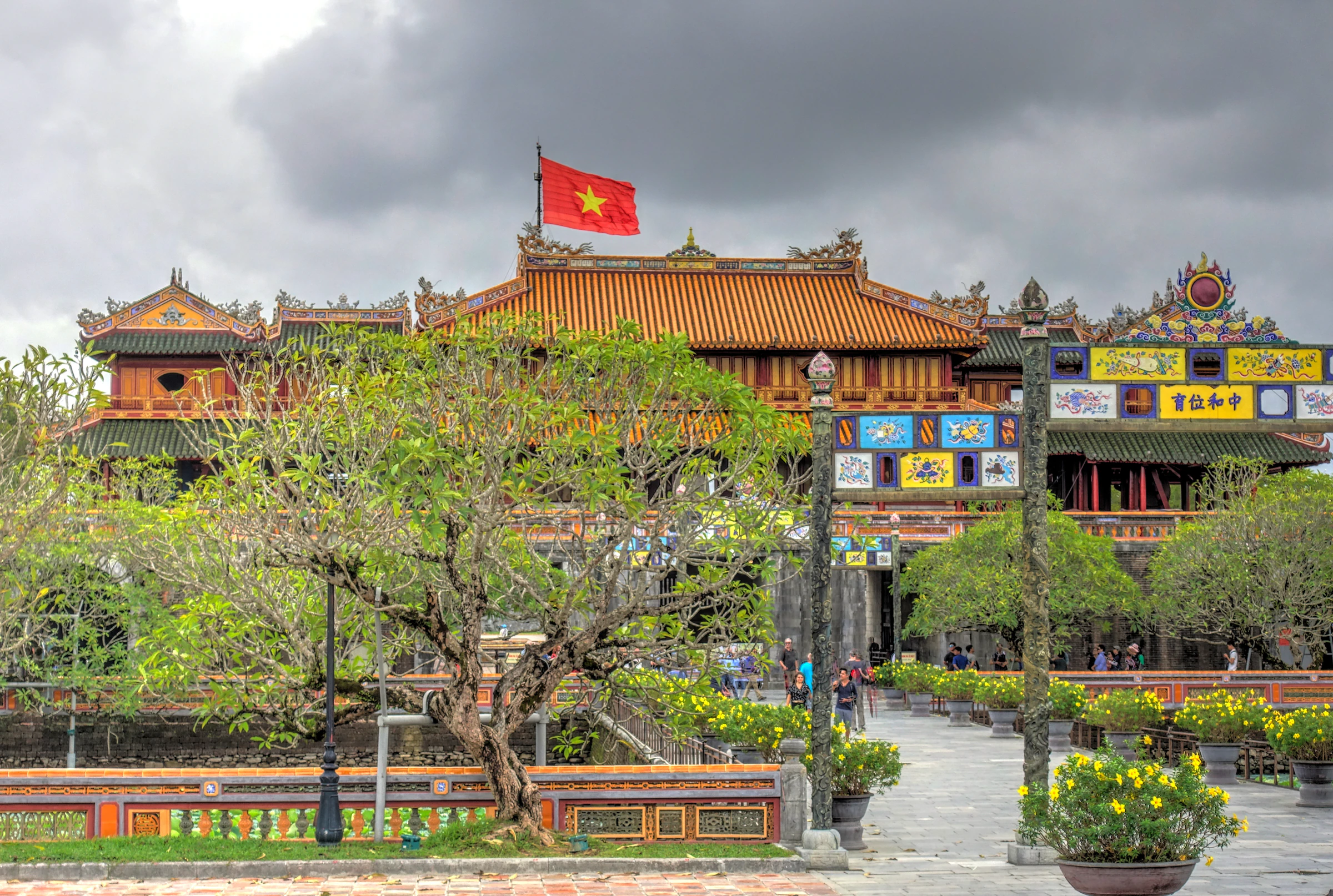 The Imperial City in Hue with a gate and flag behind the trees